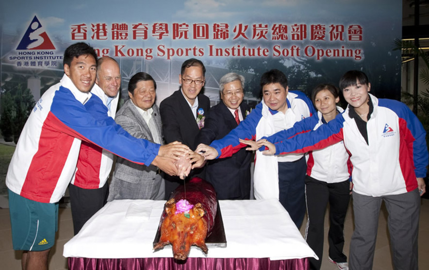 <p>At the HKSI Soft Opening, Tsang Tak-sing (4<sup>th</sup> from left), Secretary for Home Affairs; Dr Eric Li (5<sup>th</sup> from left), Chairman of HKSI; Tong Yun-kai (3<sup>rd</sup> from left), Vice President of the Sports Federation &amp; Olympic Committee of Hong Kong; Rene Appel (2<sup>nd</sup> from left), HKSI Head Windsurfing Coach; Tony Choi (3<sup>rd</sup> from right), HKSI Head Squash Coach; squash player Rebecca Chiu (2<sup>nd</sup> from right), rower Law Hiu-fung (1<sup>st</sup> from left); and wheelchair fencer Yu Chui-yee (1<sup>st</sup> from right) participate in the roast pig cutting ceremony to celebrate the soft opening of the HKSI and tour the upgraded and expanded facilities at the HKSI Fo Tan venues.</p>
