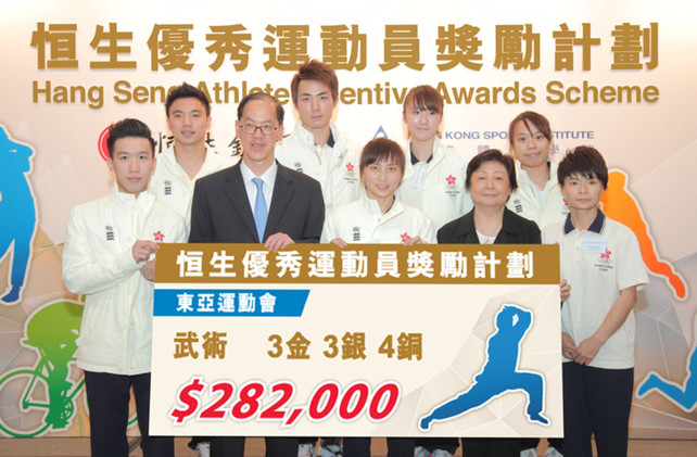 Mr Tsang Tak-sing, Secretary for Home Affairs (1st row, 2nd from left) and Ms Rose Lee, Vice-Chairman and Chief Executive of Hang Seng Bank (1st row, 2nd from right) present cash incentives to Hong Kong Wushu Team. The team collectively brought home three gold, three silver and four bronze medals from the 6th East Asian Games, receiving cash awards totalling HK$282,000 under the Hang Seng Athlete Incentive Awards Scheme, the highest amount awarded for a single sport at this year's East Asian Games.