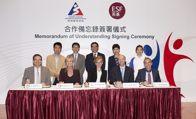 The Memorandum of Understanding is signed by Dr Trisha Leahy BBS (1st row, 3rd left), Chief Executive of the HKSI; Mrs Belinda Greer (1st row, 2nd left), Chief Executive Officer of English Schools Foundation; Dr Ed Wickins (1st row, 1st left), Principal of King George V School; Dr Harry Brown (1st row, 1st right), Principal of Renaissance College; and Mr Marc Morris (1st row, 2nd right), Principal of Sha Tin College; with the signatures witnessed by Mr Tony Yue Kwok-leung MH JP (2nd row, 2nd left), Chairman of the Elite Sports Committee; Miss Petty Lai Chun-yee, Principal Assistant Secretary for Home Affairs (Recreation & Sport) (2nd row, 2nd right); Mr Carlson Tong Ka-shing SBS JP (2nd row, 3rd left), Chairman of the HKSI; the HKSI’s Head Table Tennis Coach Chan Kong-wah (2nd row, 1st left); and wushu athlete Shum Hui-yu (2nd row, 1st right).
