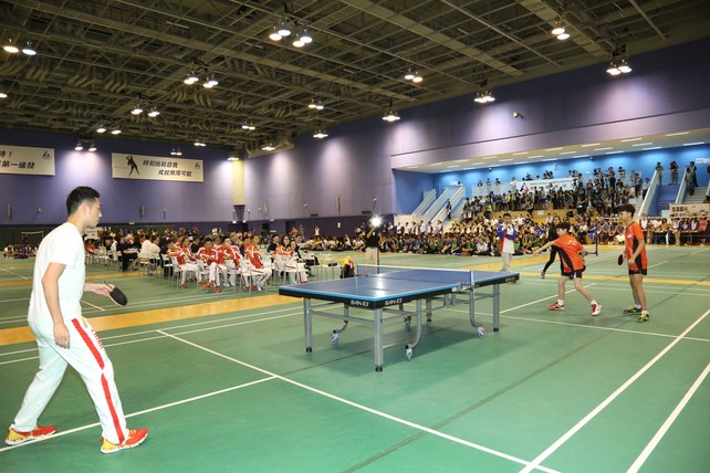 內地奧運選手許昕（左）與香港青少年運動員對打乒乓球。