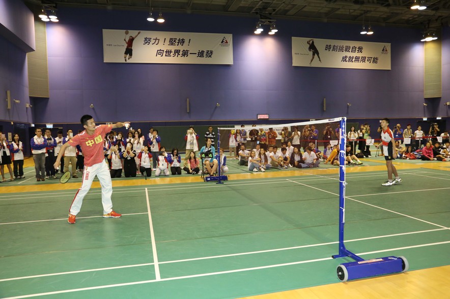 <p>內地奧運選手諶龍（左）與英皇佐治五世學校的學生對打羽毛球。</p>
