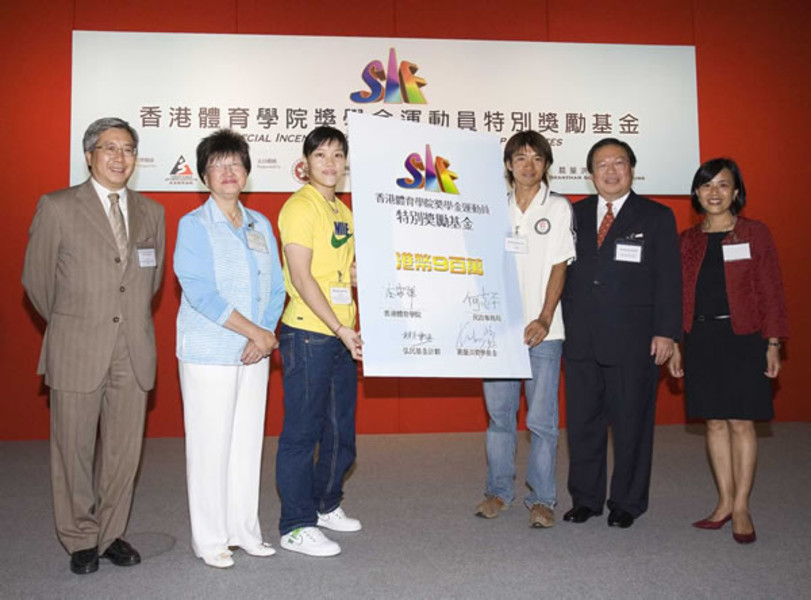 <p>Officiating guests Dr Eric Li, Chairman of the HKSI (first from left), Lam Pei-yu-dja, Member of the Advisory Committee on Disbursement of Donations of the Facility and Programme Donations Scheme (second from left), Dr Patrick Ho, Secretary for Home Affairs (fifth from left), and Chan Yin-hung, Member of the Grantham Scholarships Fund Committee (sixth from left), signed their names on a commemorative display board as a gesture of support to the HKSI Scholarship Athletes. 2005 National Games cycling bronze medallist Wong Kam-po (fourth from left) and Paralympic wheelchair fencing gold medallist Yu Chui-yee (third from left) represented benefitted athletes to receive the giant certificate of commitment.</p>
