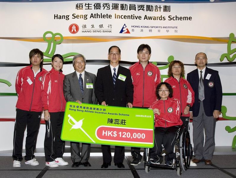 <p>體院主席李家祥博士（左三）及民政事務局局長曾德成(左四)頒發獎金予輪椅劍擊隊，表揚他們的傑出表現。</p>
