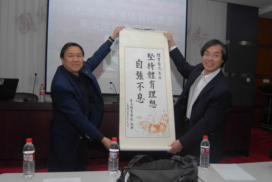 <p>Professor Li Guo-ping (left), President of the Beijing Sports Medicine Hospital, is glad to receive a tailor-made souvenir from Professor Chan Kai-ming (right), Honorary Head of Delegation.</p>
