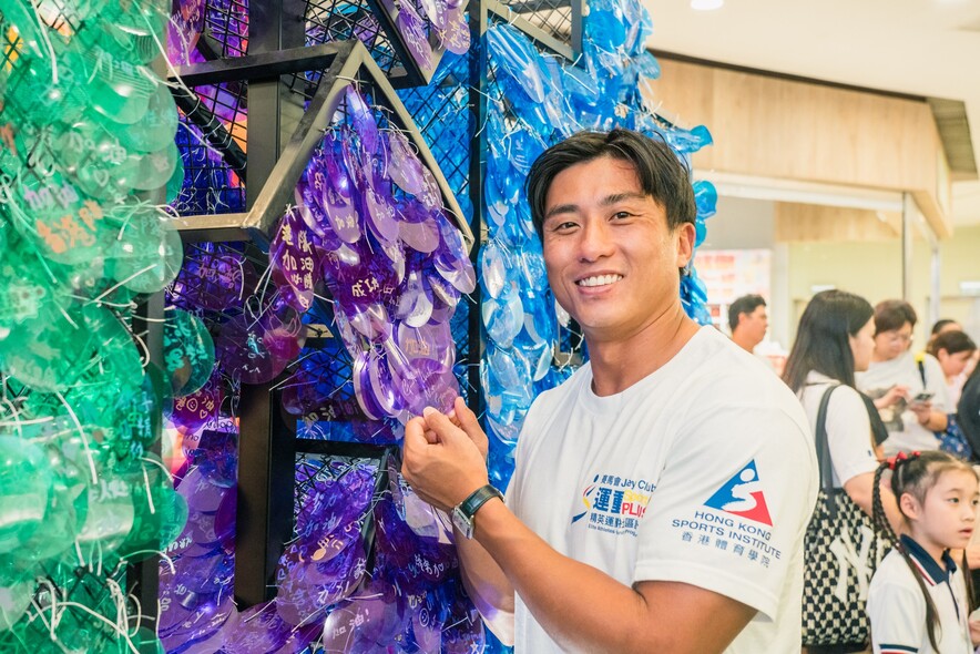 <p>Lau Chi-lung, Ho Wai-hang, Lee Ka-to and Lee Sze-wing write their own messages of support for Team Hong Kong athletes to hang on the large cheering net. The net was a feature at all four stops of the roving exhibition for members of the public to offer their support to the athletes.</p>

