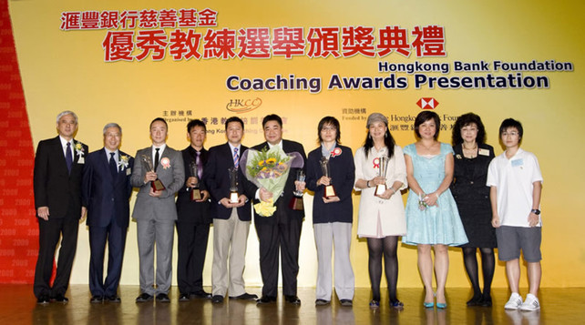 Group photo of officiating guests and recipients of the Coach of the Year Awards: wushu coach Gao Song (3rd from left), table tennis coach Li Huifen (4th from right), table tennis coach for the mentally handicapped Cui Xiaoyan (5th from right), windsurfing coach Yu Wing-ho (4th from left), and squash coach Leung Kan-fai (5th from left), together with recipient of the Distinguished Services Award for Coaching Choi Yuk-kwan (squash, middle) and squash player Lee Ka-yi (1st from right).