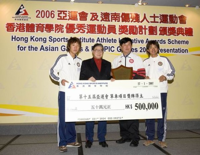 中国香港体育协会暨奥林匹克委员会会长霍震霆议员（左二）颁发现金奖励予两位亚运单车项目金牌得主：黄金宝（右一）和张敬炜（左一），并且致送纪念品予体院单车总教练沈金康（右二）。