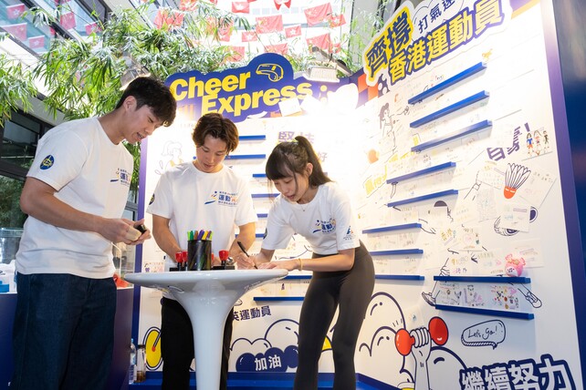 （左起）剑击运动员吴诺弘、体操运动员石伟雄和壁球运动员何子乐於赛马会「运动+」精英运动员社区计划互动展览内的「打气速递」区写下鼓励字句，为队友打气。